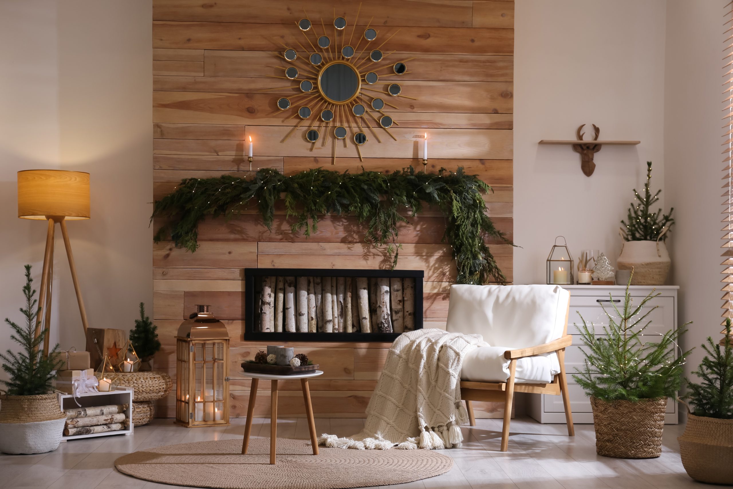 Cozy American holiday living room with Christmas garland on wood wall fireplace and candles