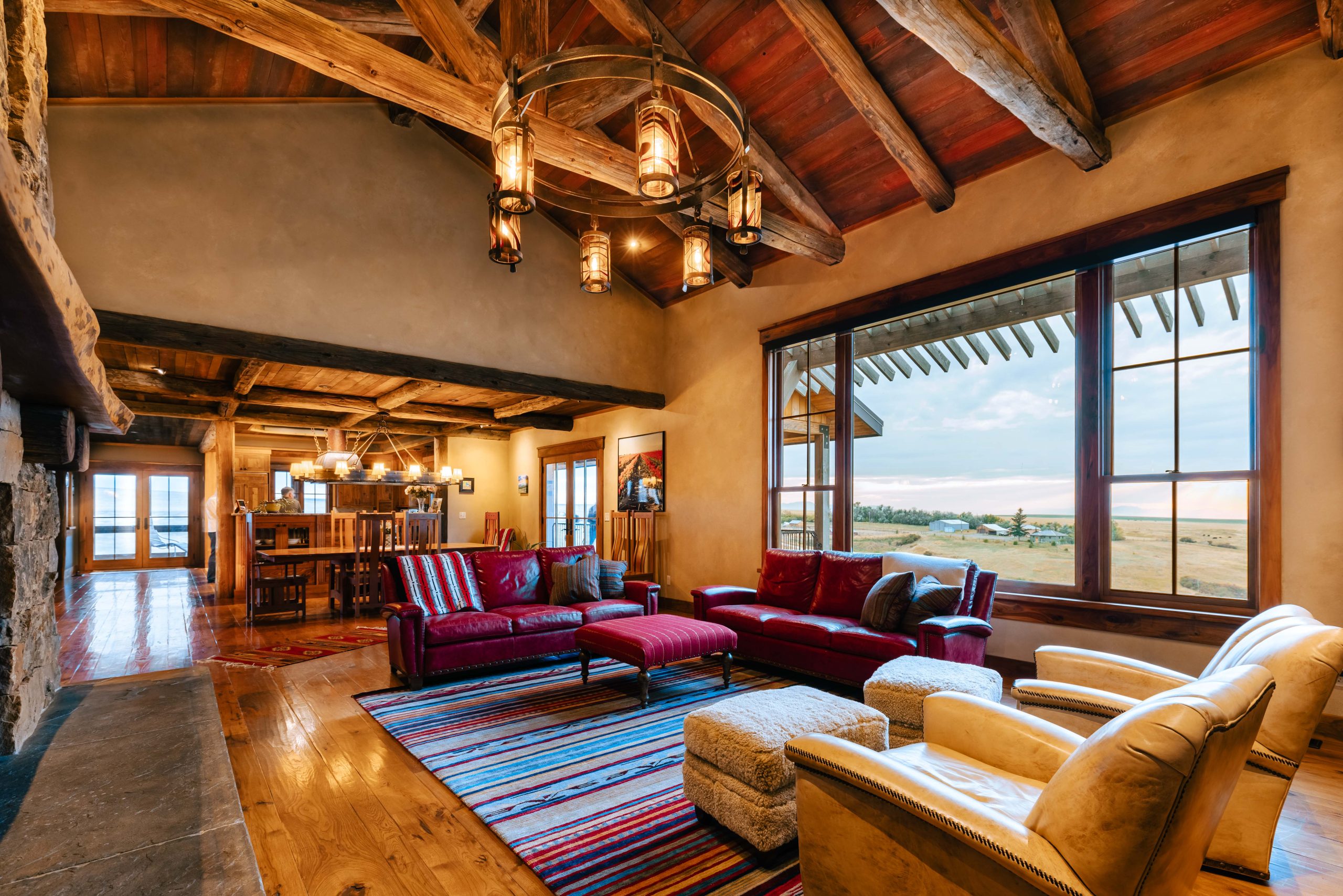 Rustic American farmhouse living room with wooden beams and open prairie view