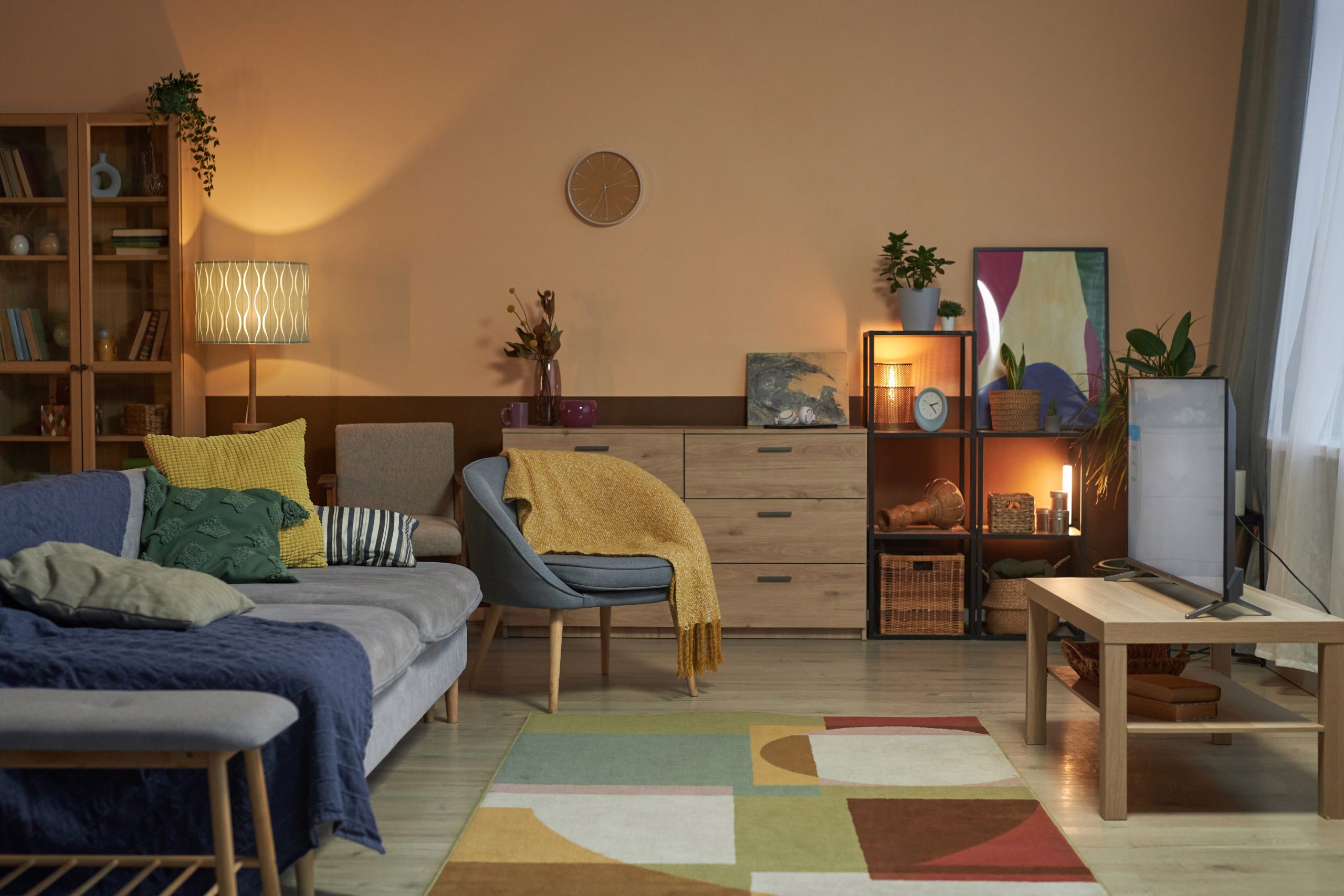 Cozy farmhouse living room with wood accent wall, candles and blue armchair
