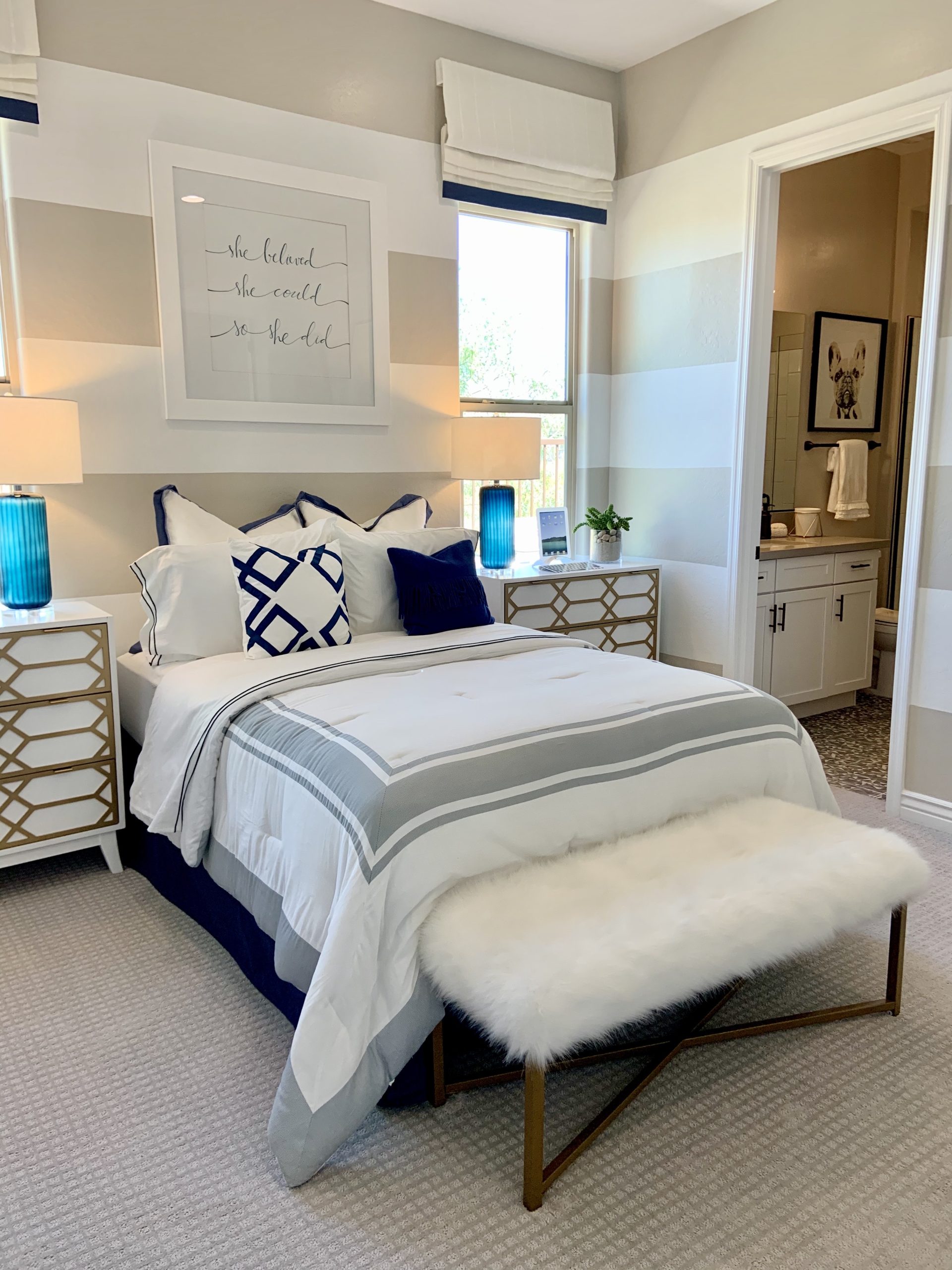 American farmhouse bedroom with navy and white striped walls and cozy bedding