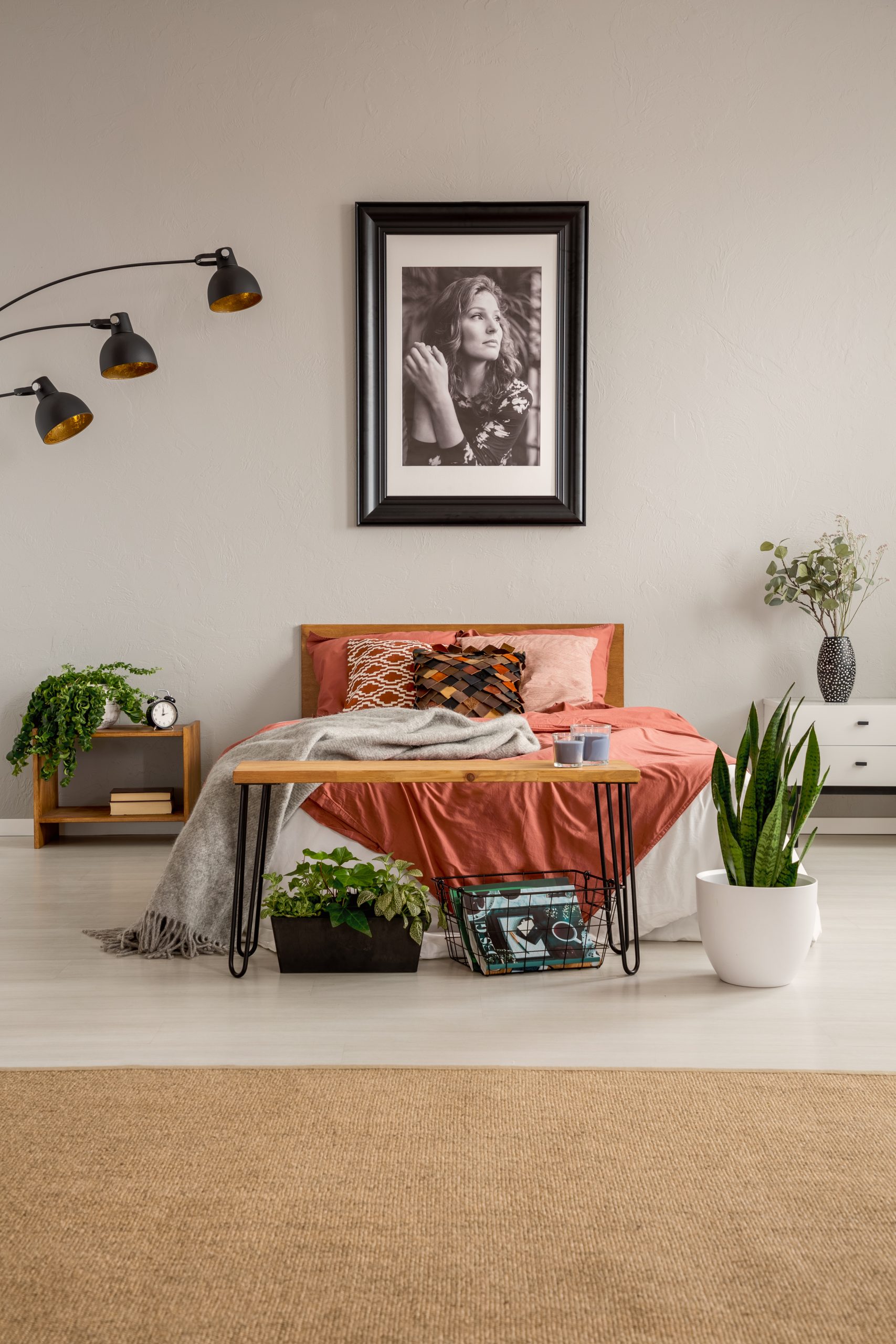 Warm farmhouse bedroom with terracotta bedding, wooden bench and indoor plants