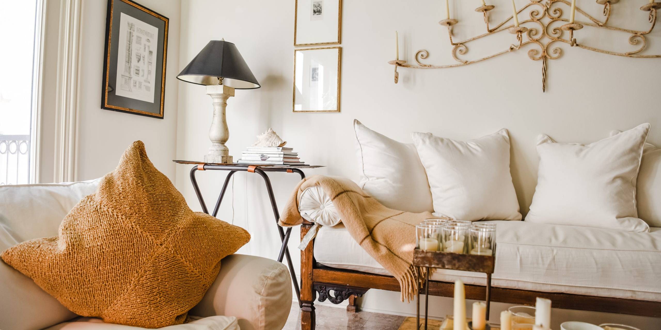 Quiet luxury American living room with white slipcovered sofa, mustard pillow and vintage iron chandelier